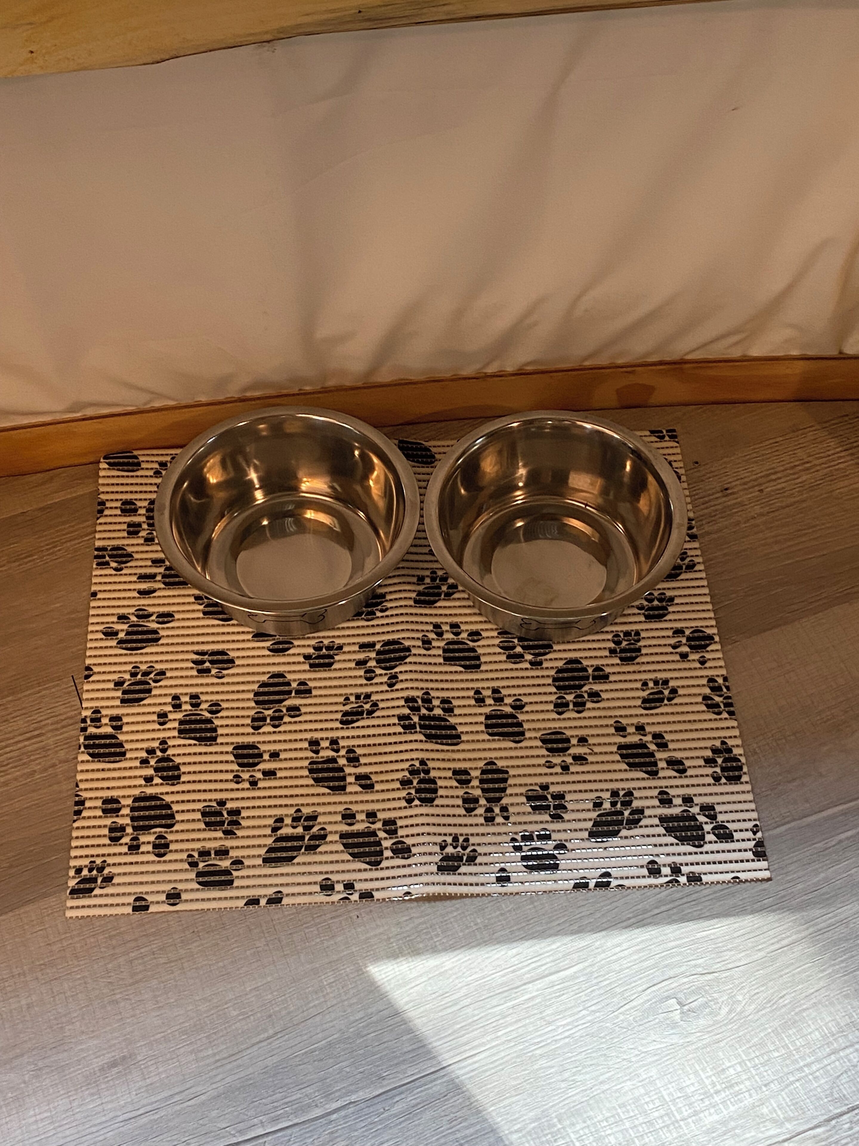 Deux bols en métal posés sur un tapis à motifs.