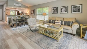 Ein geräumiges Wohnzimmer mit einer Couch, einem Couchtisch und einem Essbereich mit Stühlen und Tisch.
