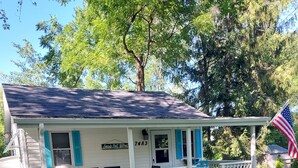 A house with a porch, a small deck, and an American flag. - Sandy beach retreat! 500 ft to beach! 3 miles to the quaint village of Lexington (Lexington)