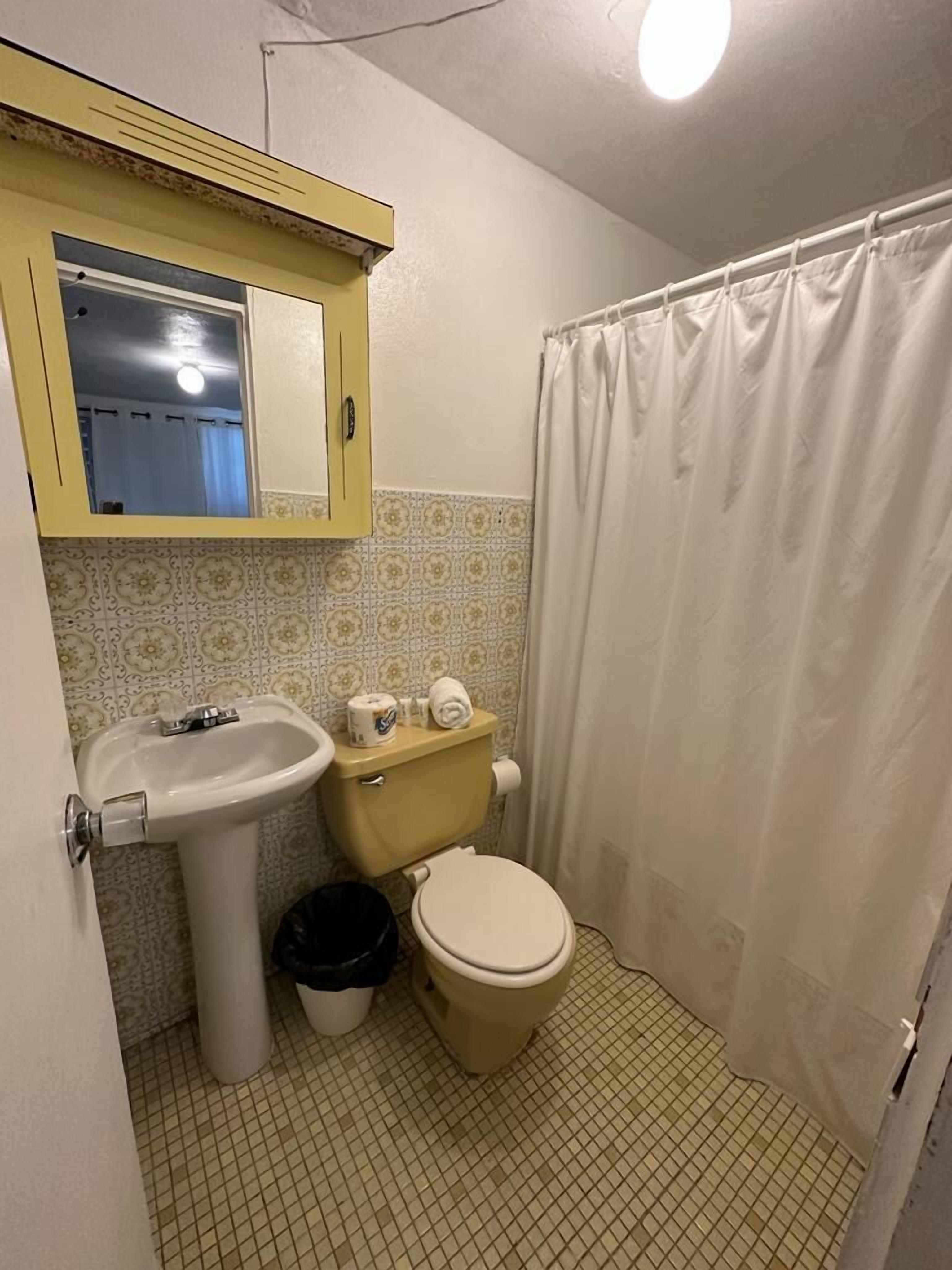 A small bathroom with a toilet, sink, and a mirror above the sink.