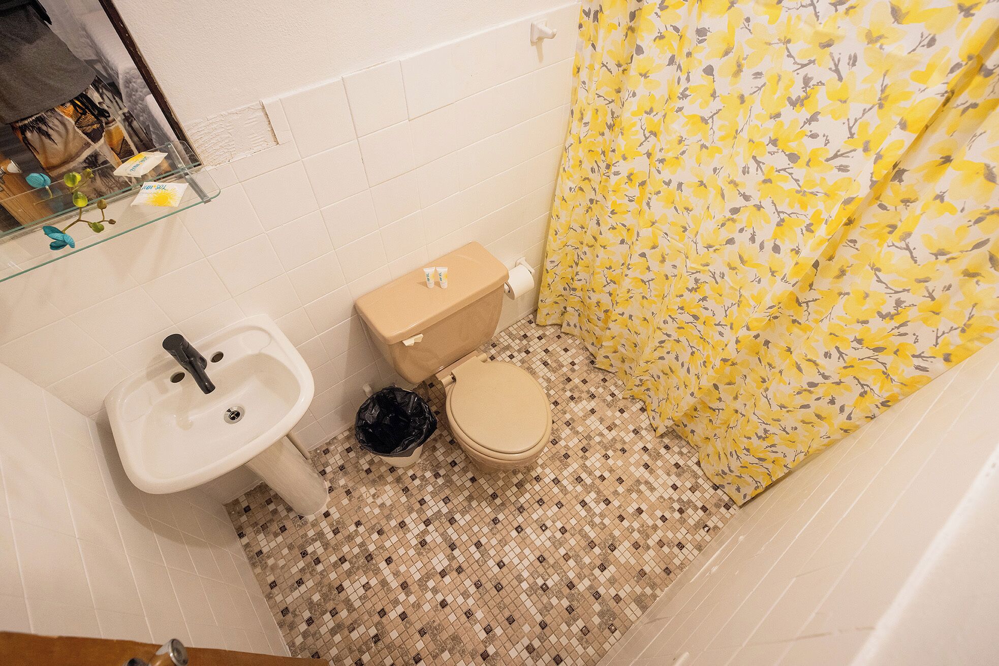 A bathroom with a toilet, sink, and shower curtain.