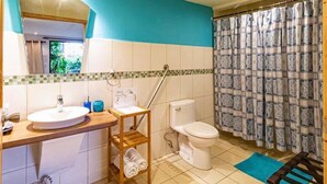 A bathroom with a sink, toilet, and shower curtain. - Posada Nena (Santa Ana)