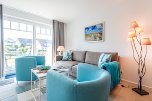 A modern living room with a sofa, two armchairs, a coffee table, and a floor lamp.
