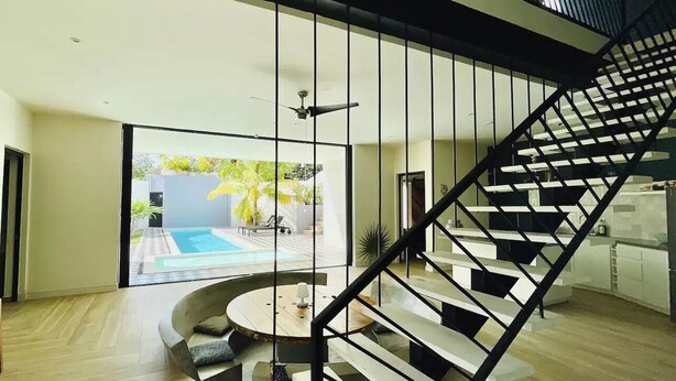 A modern interior with a staircase, a pool, and a view of the outdoors. - Casa Búho & Casa Arco (Tulum)