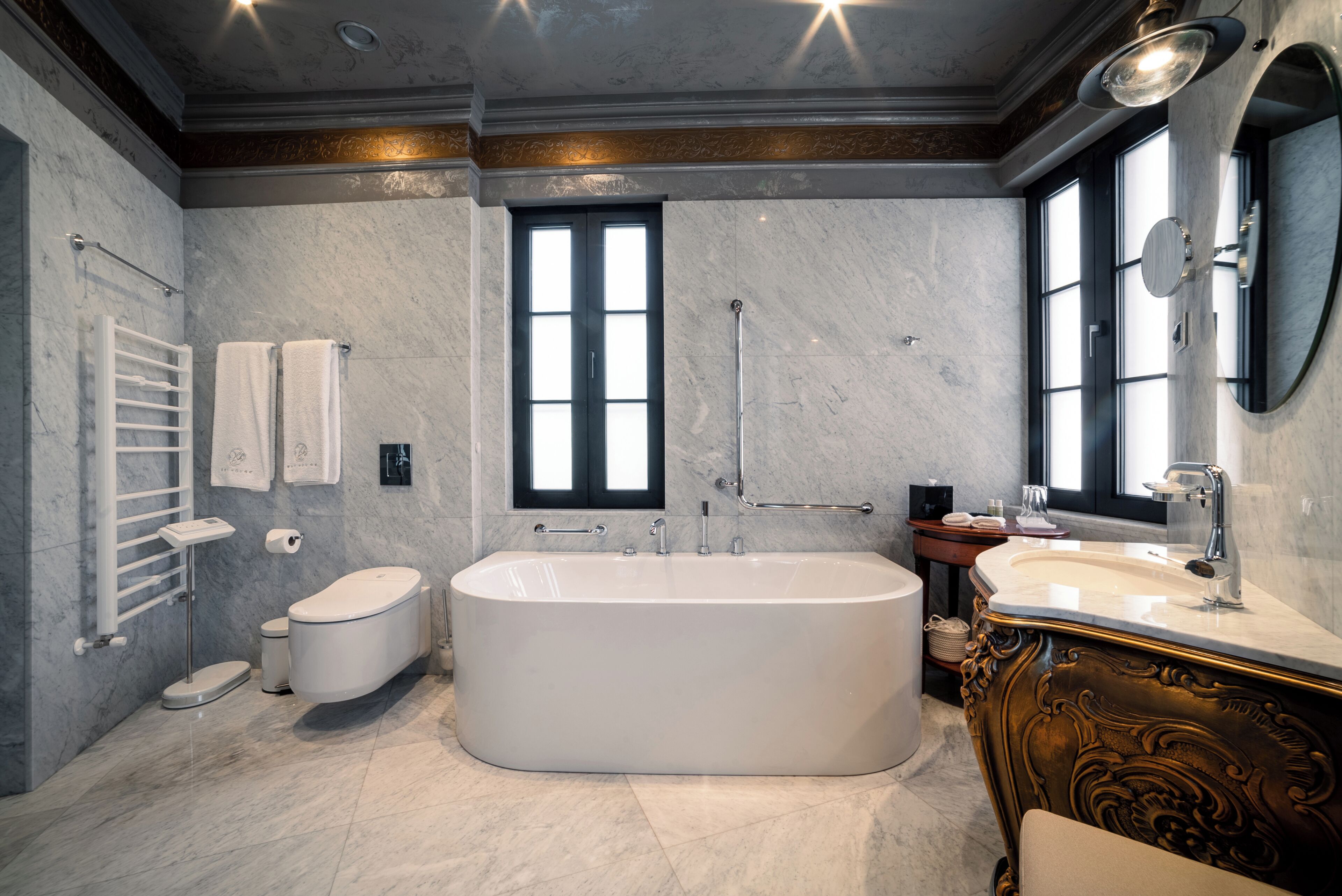 Une salle de bain moderne avec une baignoire sur pieds, un meuble-lavabo avec un miroir et des toilettes.