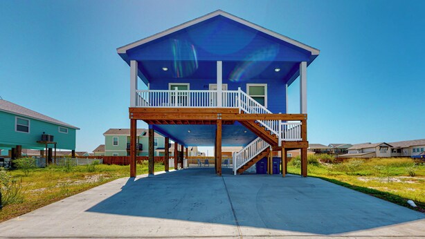 A two-story building with a balcony and a staircase. - Private Heated Pool, Pet Friendly, Parking for 5 (Port Aransas)