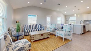 A spacious living room with a sofa, chairs, a coffee table, and a ceiling fan. - Private Heated Pool, Pet Friendly, Parking for 5 (Port Aransas)