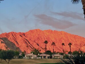 A mountain with a reddish hue, surrounded by palm trees and houses with a flat roof. - Oh, the Views! PGAWEST Palmer: 3 Bed RM, 3Bath, RARE Private Spa, so much more. (La Quinta)
