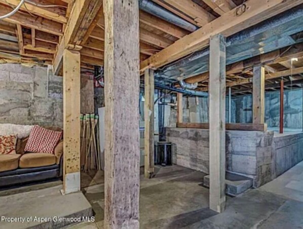 A room with exposed wooden beams, stone walls, and a stone fireplace. - An Oasis inside and out! Sweet cottage in Silt (Silt)