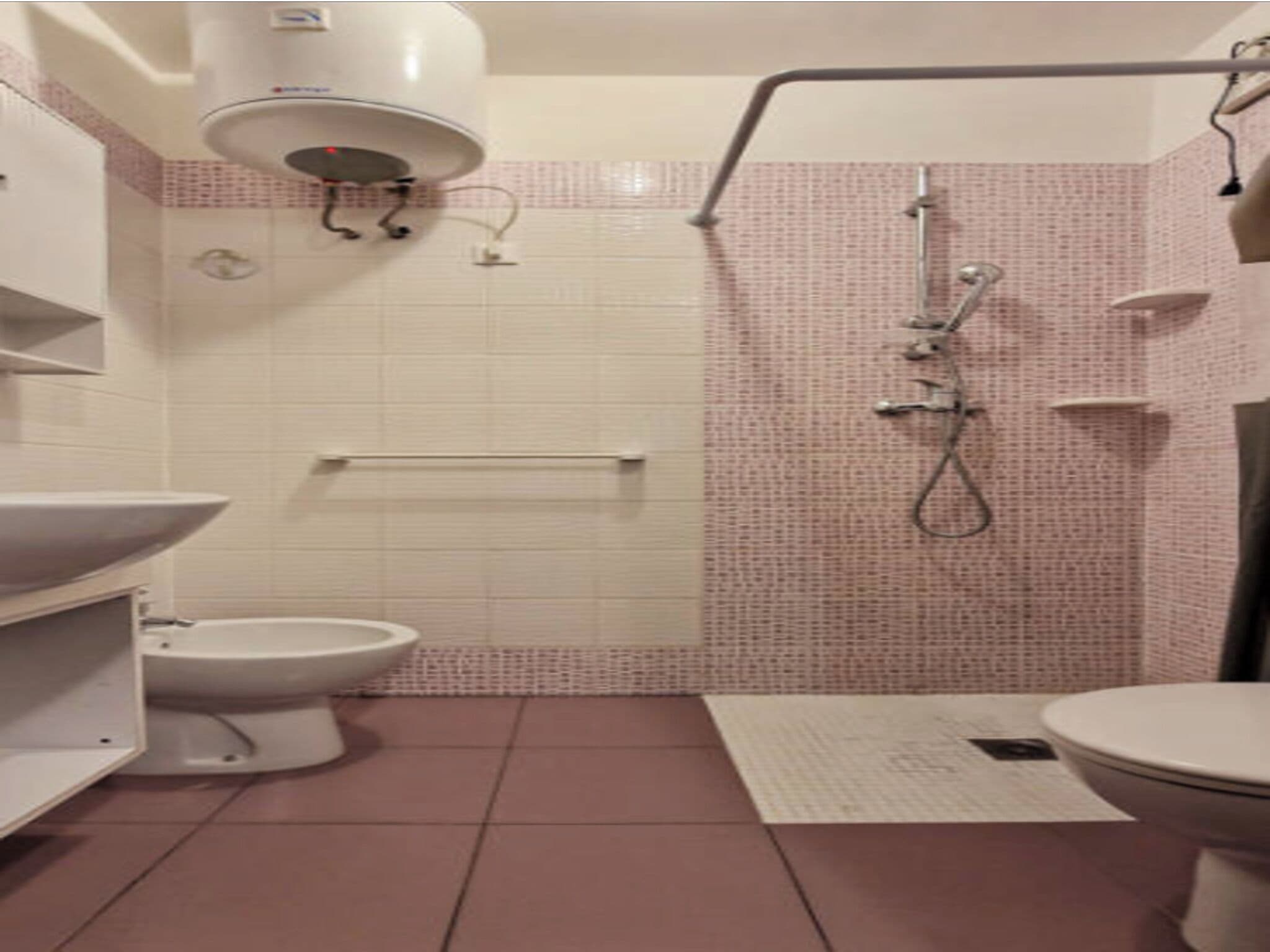 Un baño con inodoro, bidé y zona de ducha.