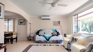 Une pièce spacieuse comprenant un lit, un canapé, une table à manger et un ventilateur de plafond.