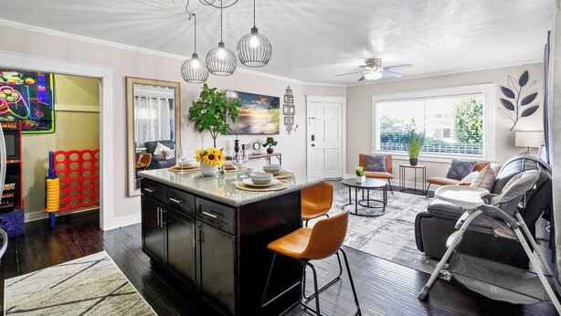 A spacious living area with a large island, dark wood flooring, and a ceiling fan. - Minutes from Beach - No Cleaning Fee - Free Parking - FIFA 2026! (Long Beach)
