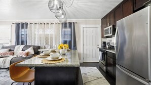 A modern kitchen with a central island, stainless steel appliances, and a dining area with a sofa and chairs. - Minutes from Beach - No Cleaning Fee - Free Parking - FIFA 2026! (Long Beach)