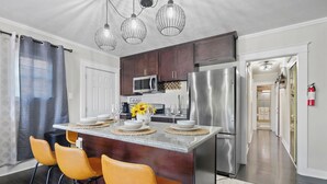 A modern kitchen with a central island, stainless steel appliances, and a dining area with yellow chairs. - Minutes from Beach - No Cleaning Fee - Free Parking - FIFA 2026! (Long Beach)