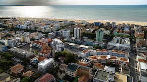 A coastal cityscape with a beach, dense urban buildings, and a mix of residential and commercial structures. - Two- Bedroom Flat With sea View in Bibione (San Michele al Tagliamento)