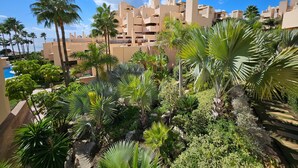 Un complexe hôtelier comprenant des bâtiments à plusieurs étages, des palmiers et une piscine.