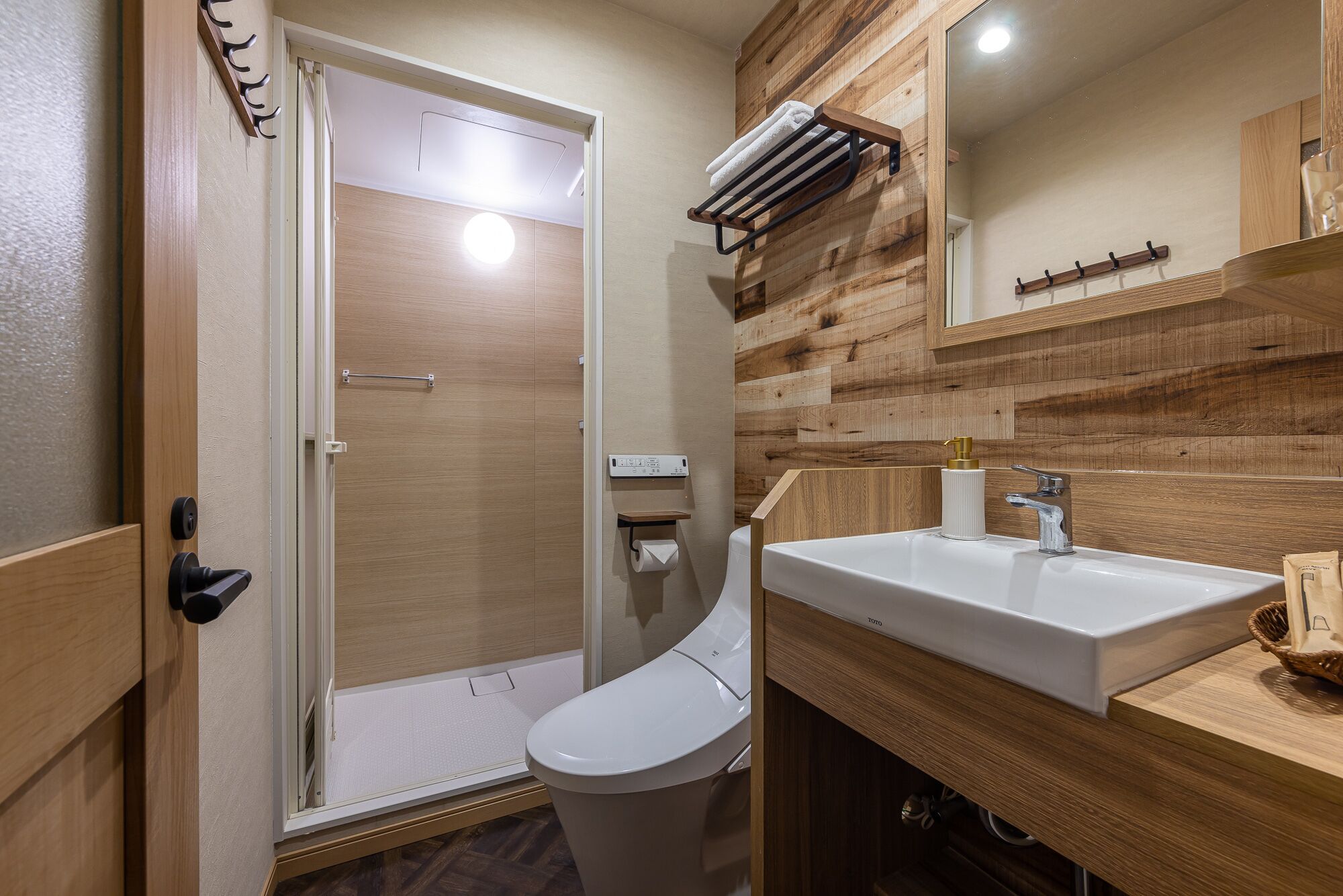 A modern bathroom with a shower, toilet, and sink.