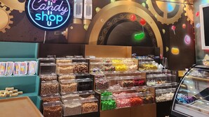 A candy shop interior with a neon sign, candy display, and decorative ceiling. - Punta Cana (Punta Cana)
