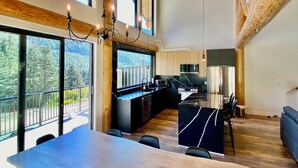 Une cuisine spacieuse dotée d’un grand îlot central, d’appareils électroménagers modernes et offrant une vue sur l’extérieur.