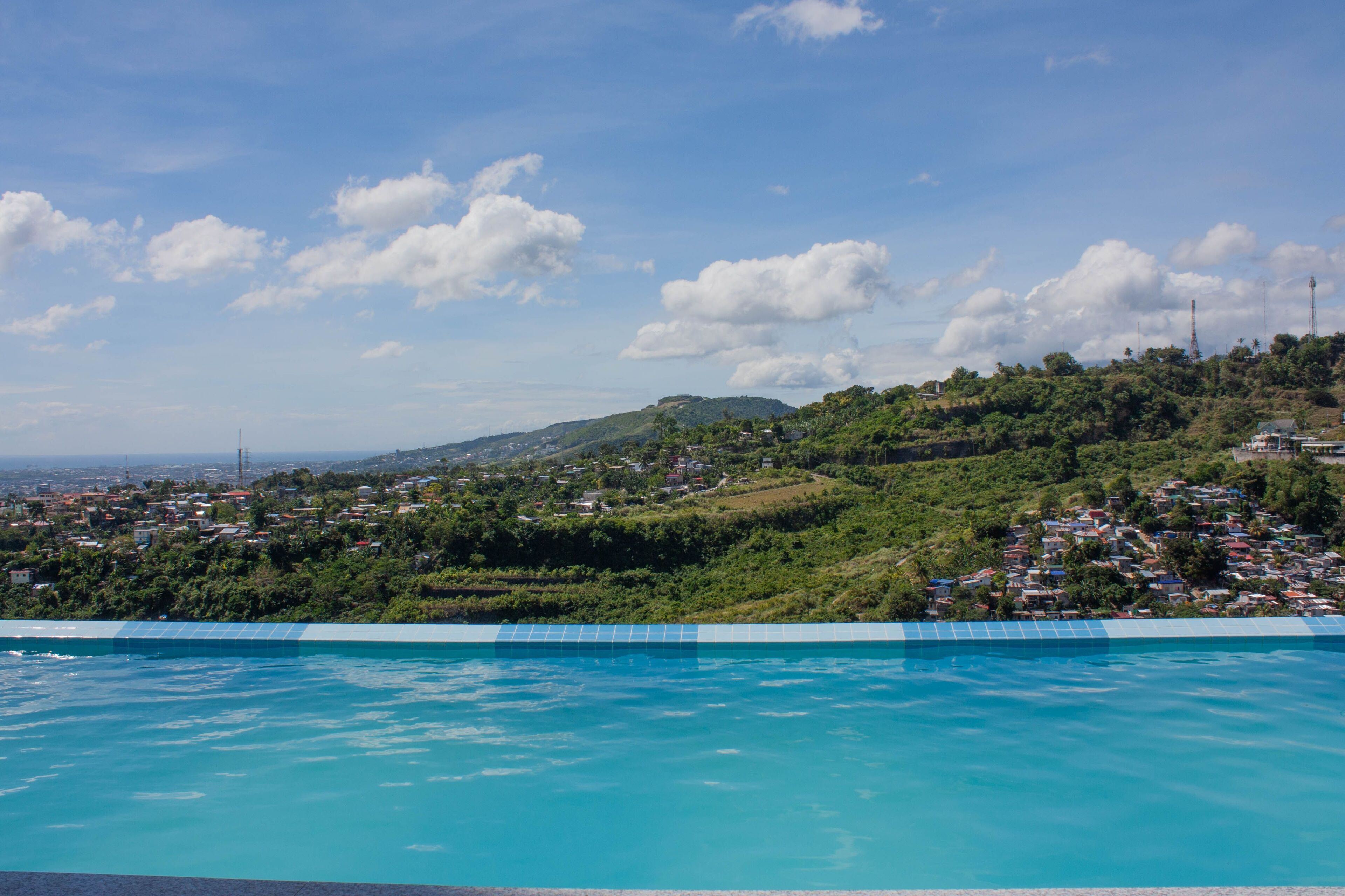 A swimming pool with a view of a hillside town.