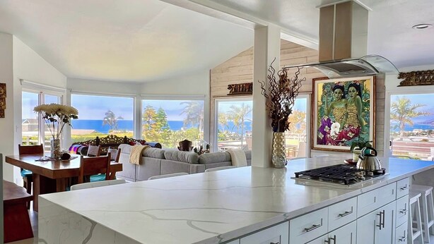 Una cocina amplia con una isla grande, muebles modernos y vistas al exterior.