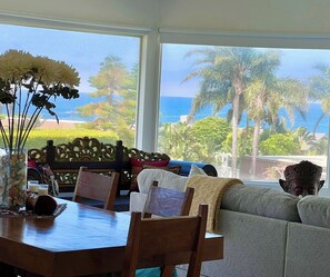 A dining area with a view of the ocean and palm trees. - Perfect Zuma Beach House - Perfect Location & View (Malibu)