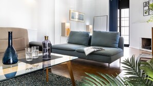 A modern living room with a glass coffee table, a sofa, and a fireplace.