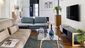 A modern living room with a sofa, coffee table, and a TV mounted on the wall.
