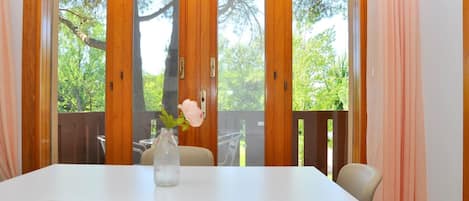 A dining area with a table, chairs, and a vase with flowers.