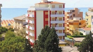 A multi-story building with balconies, a flat roof, and a view of the sea. - Three-bedroom Apartment Very Close to the Beach (San Michele al Tagliamento)