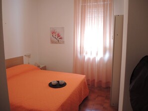 A room with a bed, a painting on the wall, and a door. - Flat 100 m From the Beach With Sunny Balcony (San Michele al Tagliamento)