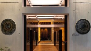 A modern reception area with a wooden floor, two circular wall decorations, and a sign indicating the reception. - Horizon by SkyCity  (Auckland)