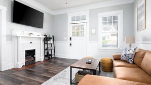 A living room with a fireplace, a television, a sofa, and a coffee table.
