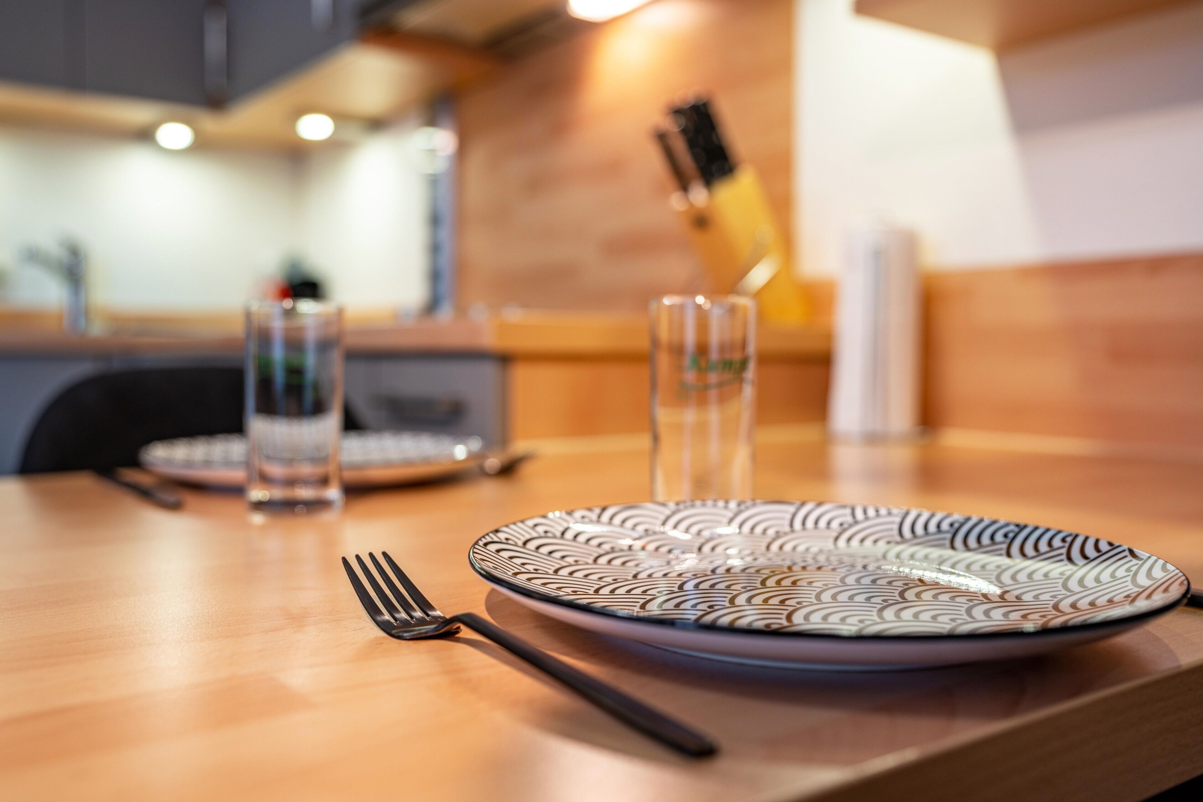 Een eettafel met een bord, vork en glas.