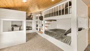 A bunk bed room with a wooden ceiling and white walls. - Elk Ridge Retreat-25m to Yellowstone+hot tub+home theater (island park)