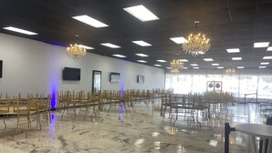A spacious hall with rows of wooden chairs, chandeliers, and a marble floor. - Amazing Event Space with Ample Parking  (Marietta)