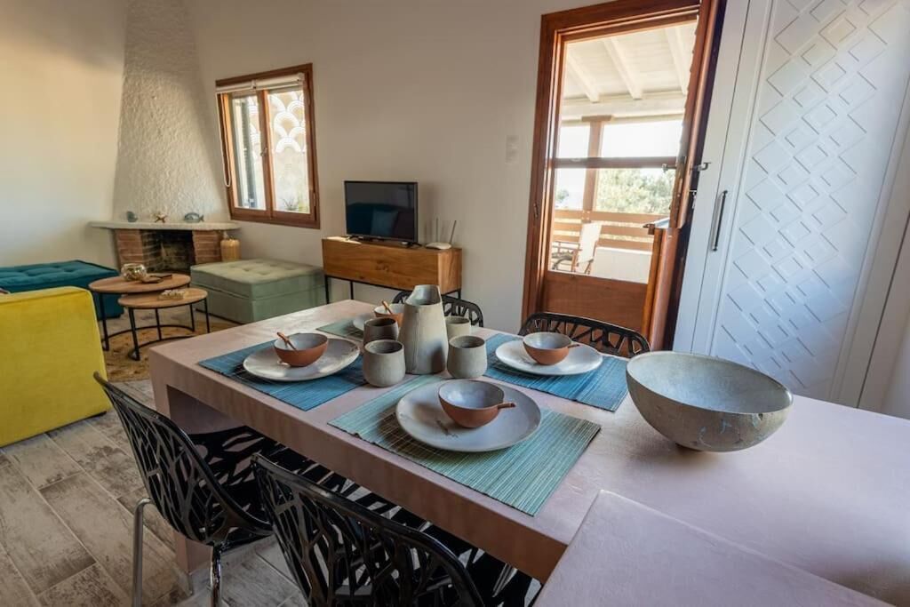 Uma sala de jantar com uma mesa posta para quatro pessoas, uma televisão e uma lareira.