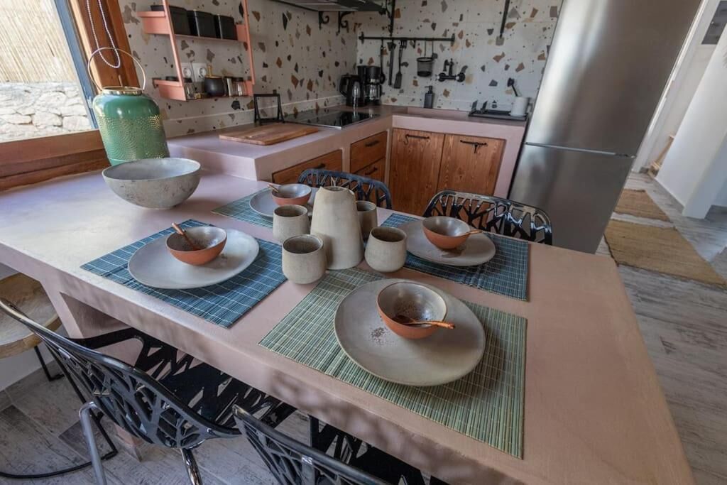 A kitchen with a central island, a sink, and a refrigerator.