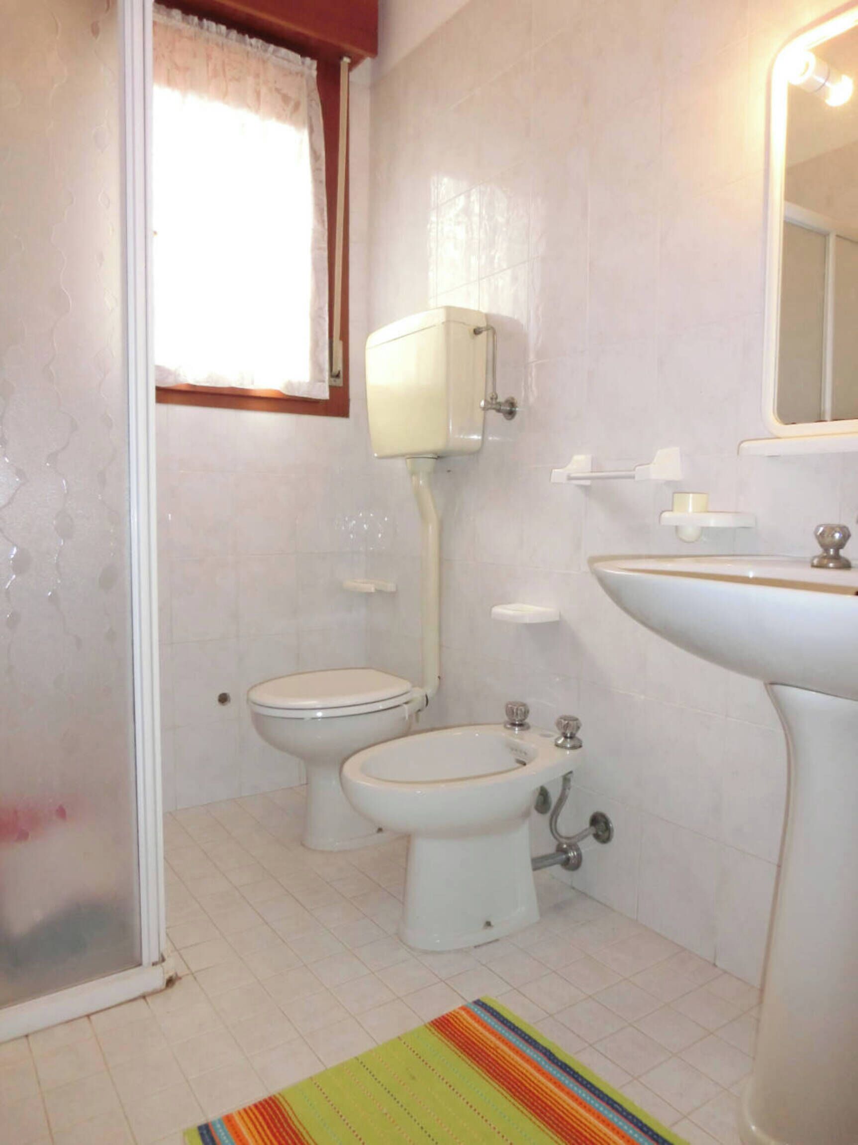 A bathroom with a toilet, bidet, and sink.