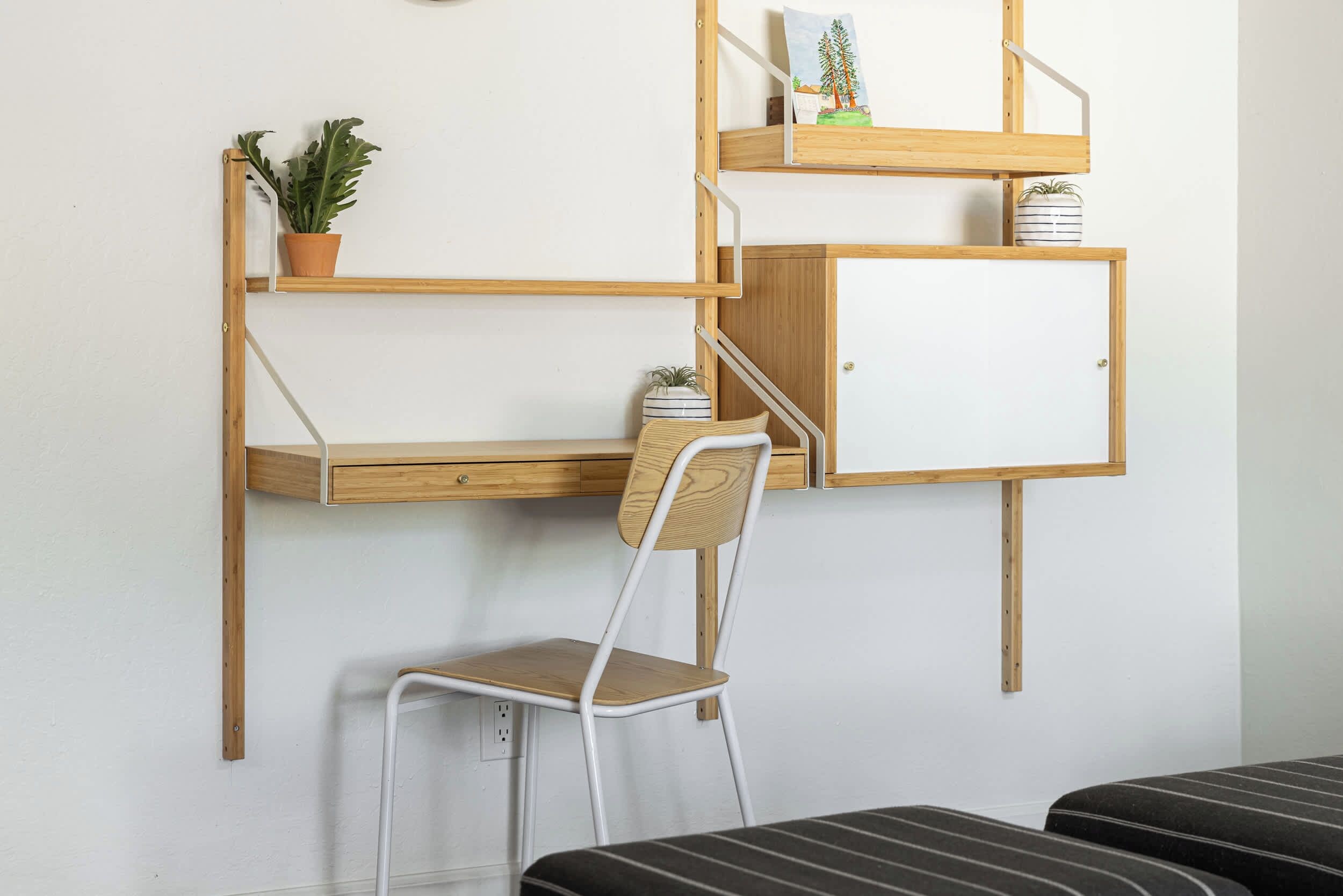Une chambre avec un lit superposé, un bureau avec une chaise et un placard.
