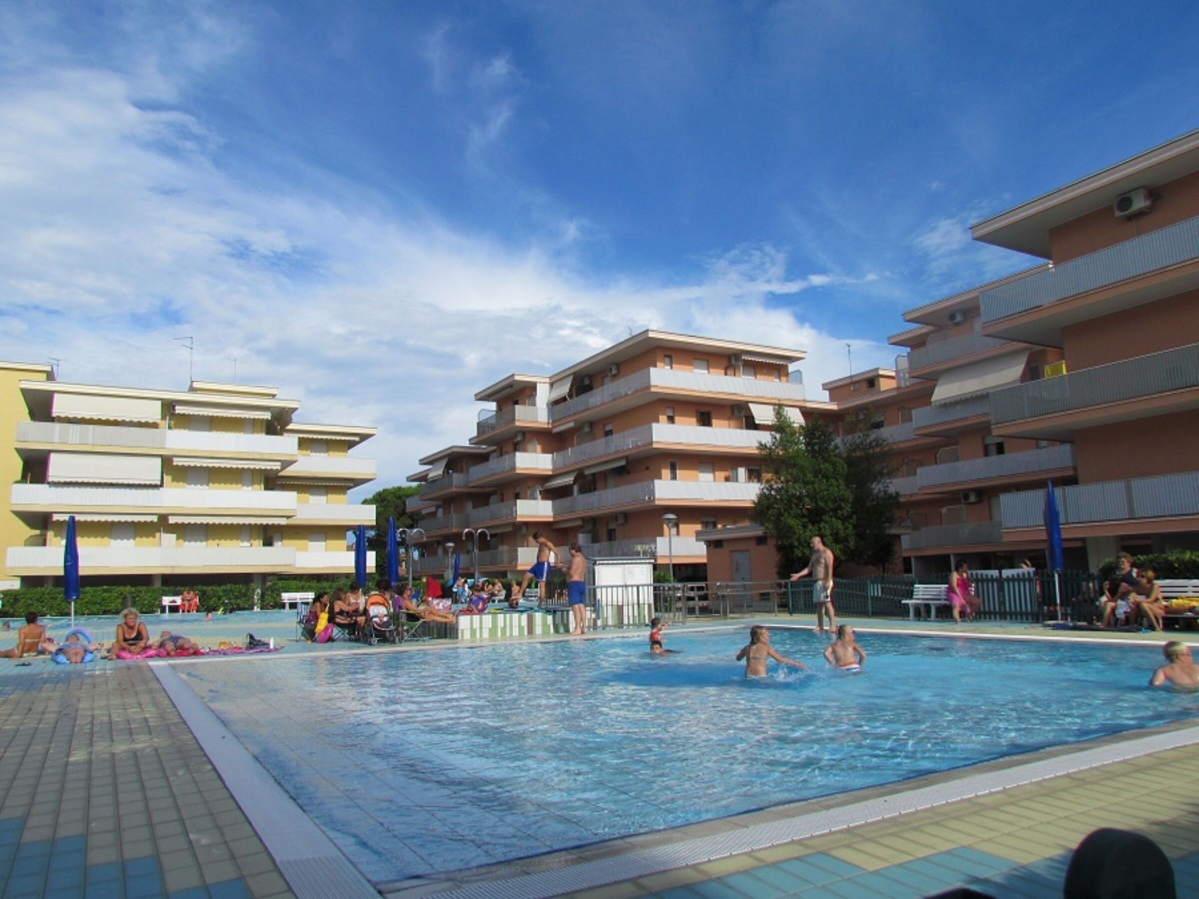 A swimming pool surrounded by multi-story buildings with balconies.