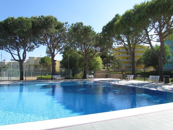 A swimming pool surrounded by trees and buildings. - Spend Your Holiday in an Amazing Residence (San Michele al Tagliamento)