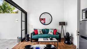 A modern living room with a sofa, coffee table, and a large mirror. - Villa Balik II Seminyak (Seminyak)