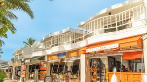 Eine Uferstraße mit Geschäften, darunter ein Orange Corner Eisstand.