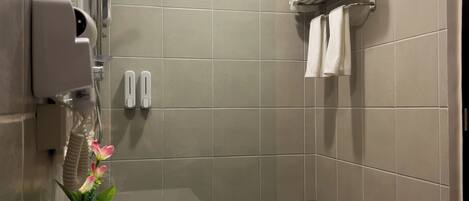 Une salle de bain moderne équipée d’une douche, d’un lavabo et d’un porte-serviettes.