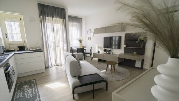 Ein modernes Wohnzimmer mit einer Couch, einem Couchtisch und einem Essbereich mit Tisch und Stühlen.