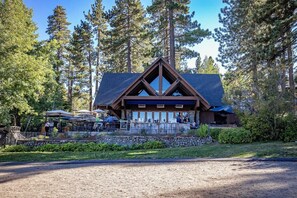 Surrounded by a lush forest, this lodge offers a covered outdoor seating area perfect for dining or socializing.