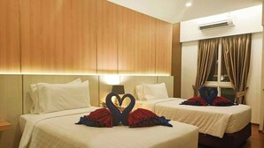 A hotel room with two beds, wooden paneling on the walls, a large window with curtains, and a heart-shaped decoration on the beds. - M CASA HOTEL PATTAYA (Pattaya)