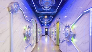 Een hal met een futuristisch ontwerp, met metalen elementen en een spiegelende vloer.