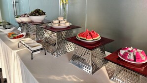 Een buffetopstelling met diverse gerechten en een decoratieve bloemstuk met gele bloemen.